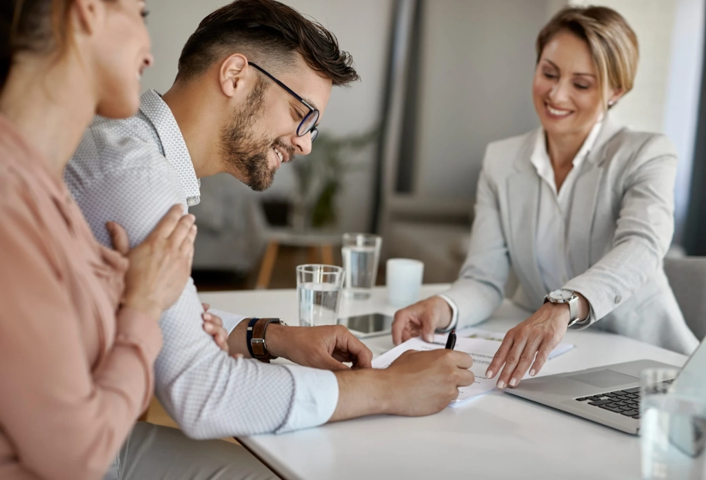 cropped-homme-heureux-sa-femme-ayant-reunion-conseiller-financier-signant-accord-au-bureau-scaled-1